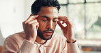 Home, headache and man in lounge, pain and stress with brain fog, worry and tension. Apartment, exhausted and person with migraine, fatigue or tired with pressure, temple massage or sick with burnout