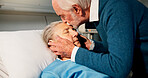 Senior man, woman and kiss in hospital bed with sleeping, greeting and love for recovery in retirement. Old couple, patient and partner with kindness, support and embrace for rehabilitation at clinic