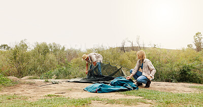 Buy stock photo Couple, camping and pitch tent in nature with gear, help and space in sky for holiday adventure in summer. Woman, man and teamwork with shelter construction on vacation, trip and getaway in bush