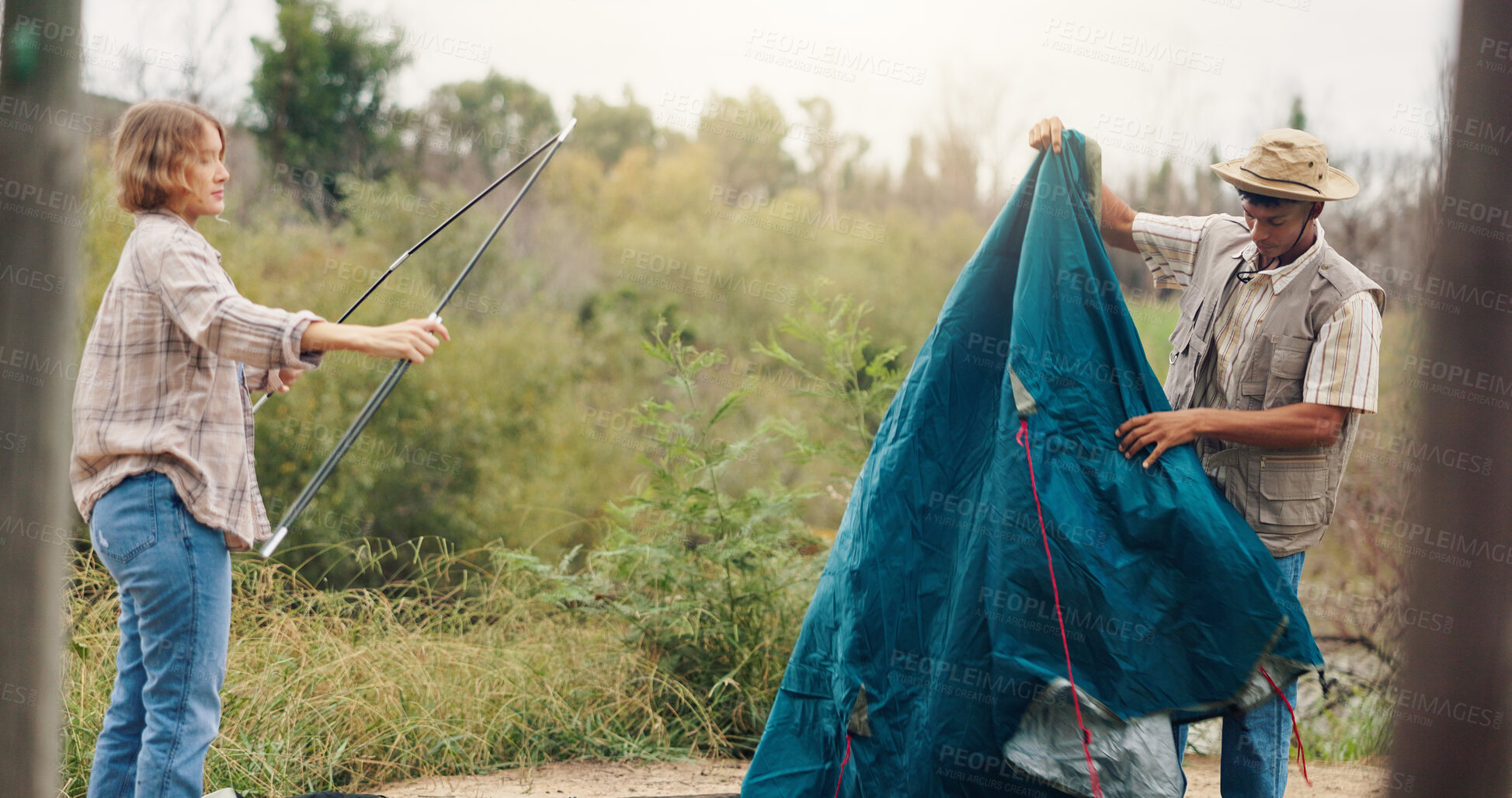 Buy stock photo Couple, tent and setting camp with rods in forest for outdoor stay, adventure or travel together. Man, woman and campers with equipment or preparation for safety, shelter or protection in wilderness