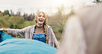 Smile, woman and pitching tent in nature for camping, vacation adventure and bonding together. Couple, partner help and setup equipment as outdoor shelter, campsite preparation and wilderness holiday