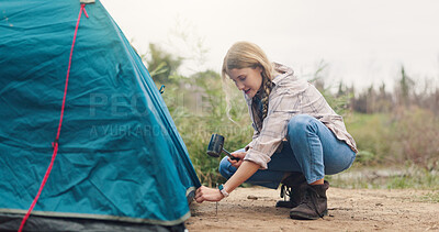 Buy stock photo Camping, woman and tent with hammer in nature for gear security, holiday adventure or preparation. Countryside, travel and person pitching shelter at campsite for weekend vacation, survival or safety