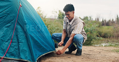 Buy stock photo Camping, man and tent with hammer in nature for gear security, holiday adventure or preparation. Countryside, travel and person pitching shelter at campsite for weekend vacation, survival and freedom