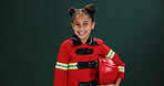 Happy girl, portrait and firefighter with helmet in studio for career day on a green background. Child, kid or smile with costume or outfit for advertising, marketing or safety tips on mockup space