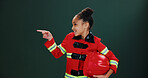 Happy girl, firefighter and pointing with helmet in studio for career day on a green background. Child, kid or smile with costume or outfit for advertising or marketing safety tips on mockup space