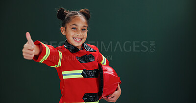 Buy stock photo Happy girl, portrait and firefighter with thumbs up in studio for career day on a green background. Child, kid or smile with like emoji, yes sign or OK in costume for safety success on mockup space