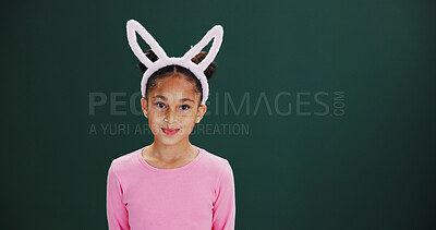 Buy stock photo Portrait, bunny ears and girl in studio, easter celebration and happiness on green background. Mockup space, kid and child with confidence, promotion and announcement with rabbit costume and festival