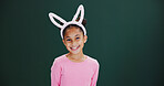 Portrait, bunny ears and girl in studio, smile and happiness on green background. Mockup space, kid and child with confidence, promotion and announcement with easter celebration, pride and festival