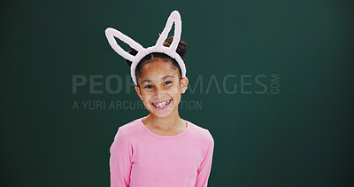 Buy stock photo Portrait, bunny ears and girl in studio, smile and happiness on green background. Mockup space, kid and child with confidence, promotion and announcement with easter celebration, pride and festival