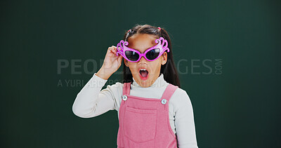 Buy stock photo Girl, sunglasses and fashion with shock in studio for funky style or news on a green background. Portrait, child or kid with wow or surprise for stylish shades, accessory or reaction on mockup space