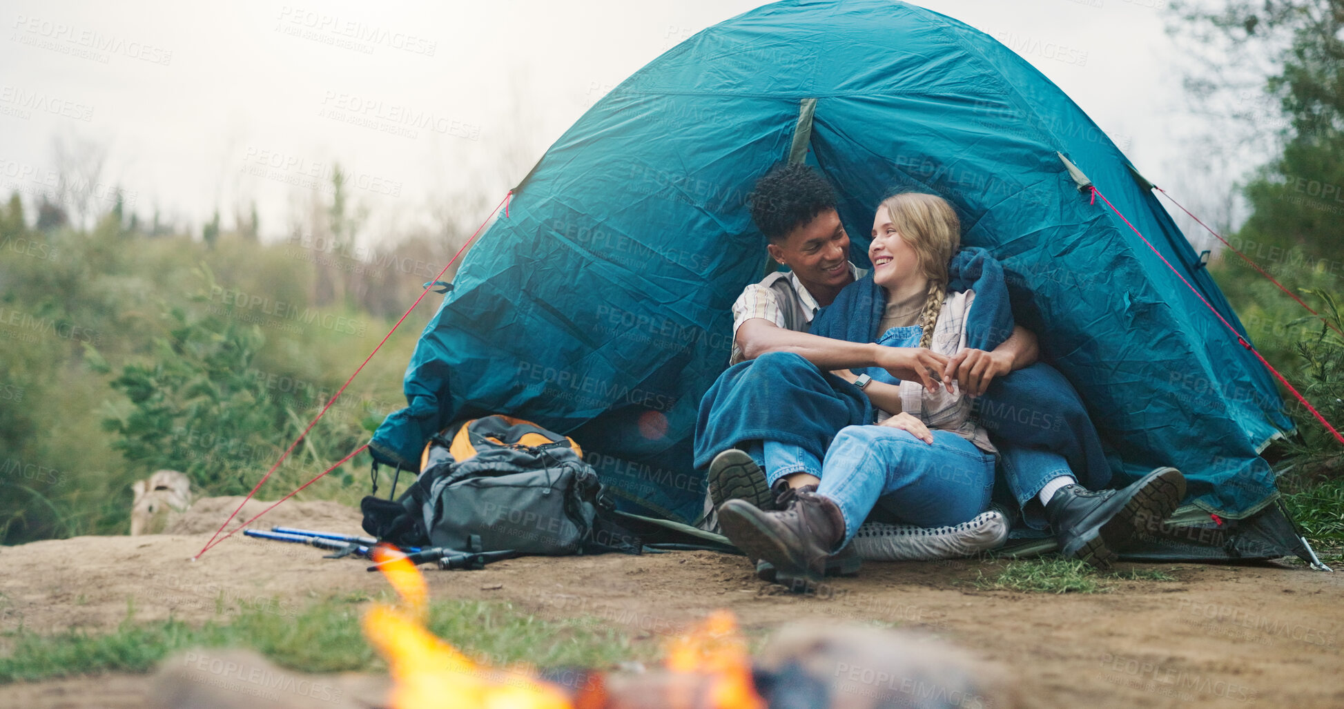 Buy stock photo Happy couple, tent and hug with fire for camping, outdoor vacation or holiday together in nature. Man, woman or love with smile, flame or shelter for safety, security or protection in wilderness