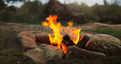 Buy stock photo Campsite, rocks and fire with nature with outdoor, survival or burning with camping wood. Empty, flames for heat or forest with adventure, field or smoke with pit for cooking on the ground with grass