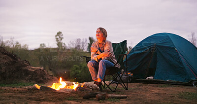 Buy stock photo Camping, woman and thinking by fire in nature for warmth, holiday reflection and travel adventure. Countryside, thoughtful and person with campfire for peaceful vacation, eco friendly comfort or dusk