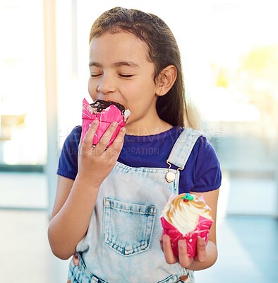 Buy stock photo Home, enjoy and girl with cupcake, eating and sweets for food, hungry and chocolate for breakfast in kitchen. House, choice and kid with dessert, candy and muffin for morning, delicious and tasty