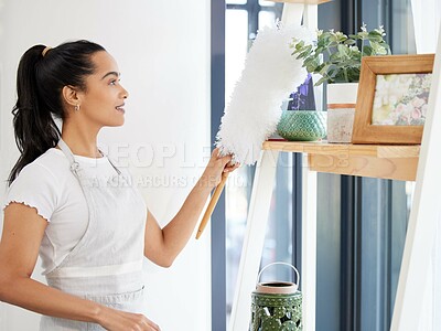 Buy stock photo Duster, woman and cleaning dust in home for housekeeping, furniture and maintenance with hygiene. Girl, happy and dusting shelf for housework with brush in house, living room and work in hospitality.