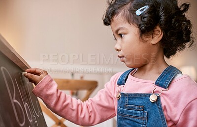 Buy stock photo Shot of a little girl writing on a blackboard at home