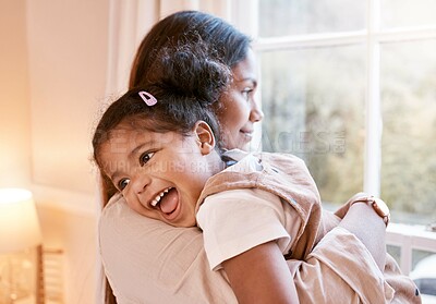 Buy stock photo Shot of a young mother embracing her daughter at home