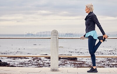 Buy stock photo Senior woman, fitness and stretching at beach promenade for exercise, wellness and thinking on sky mockup. Lady, runner and person warm up legs at sea, healthy workout and running mindset at ocean