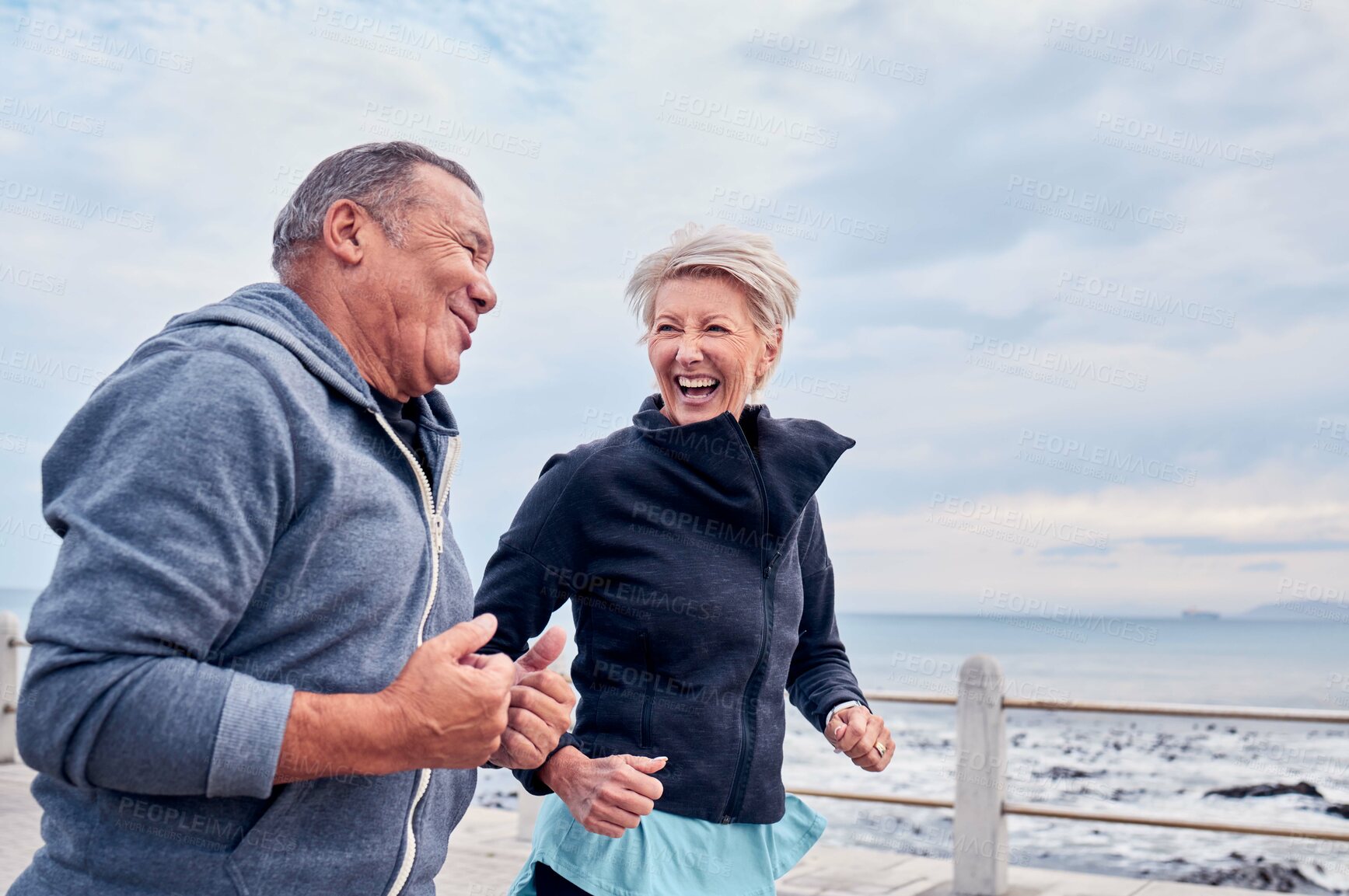 Buy stock photo Running, fitness and senior couple laugh by ocean for exercise, healthy body and wellness in retirement. Sports, marriage and happy elderly man and woman for smile, cardio workout and training by sea
