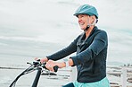 Senior woman, bike and smile in cycling by the beach for fun activity or travel in the city. Happy elderly woman smiling and enjoying cruise on bicycle for traveling, trip or fitness by ocean coast