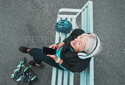 Buy stock photo Phone, happy and woman roller skating with music for training, exercise and fun on a city bench. Laughing, mobile and above of a mature lady listening to a podcast while ready to start a skate