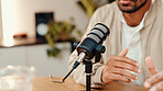 Hands, man and speaking with mic for podcast, audio broadcast and live recording in studio. Closeup, male presenter and hosting talk show for media production, content creator and radio announcement