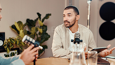 Buy stock photo Podcast, mic and man with guest in studio for interview, conversation and broadcast for radio show. Content creation, hosting and presenter with person on tablet for recording, live stream or talking
