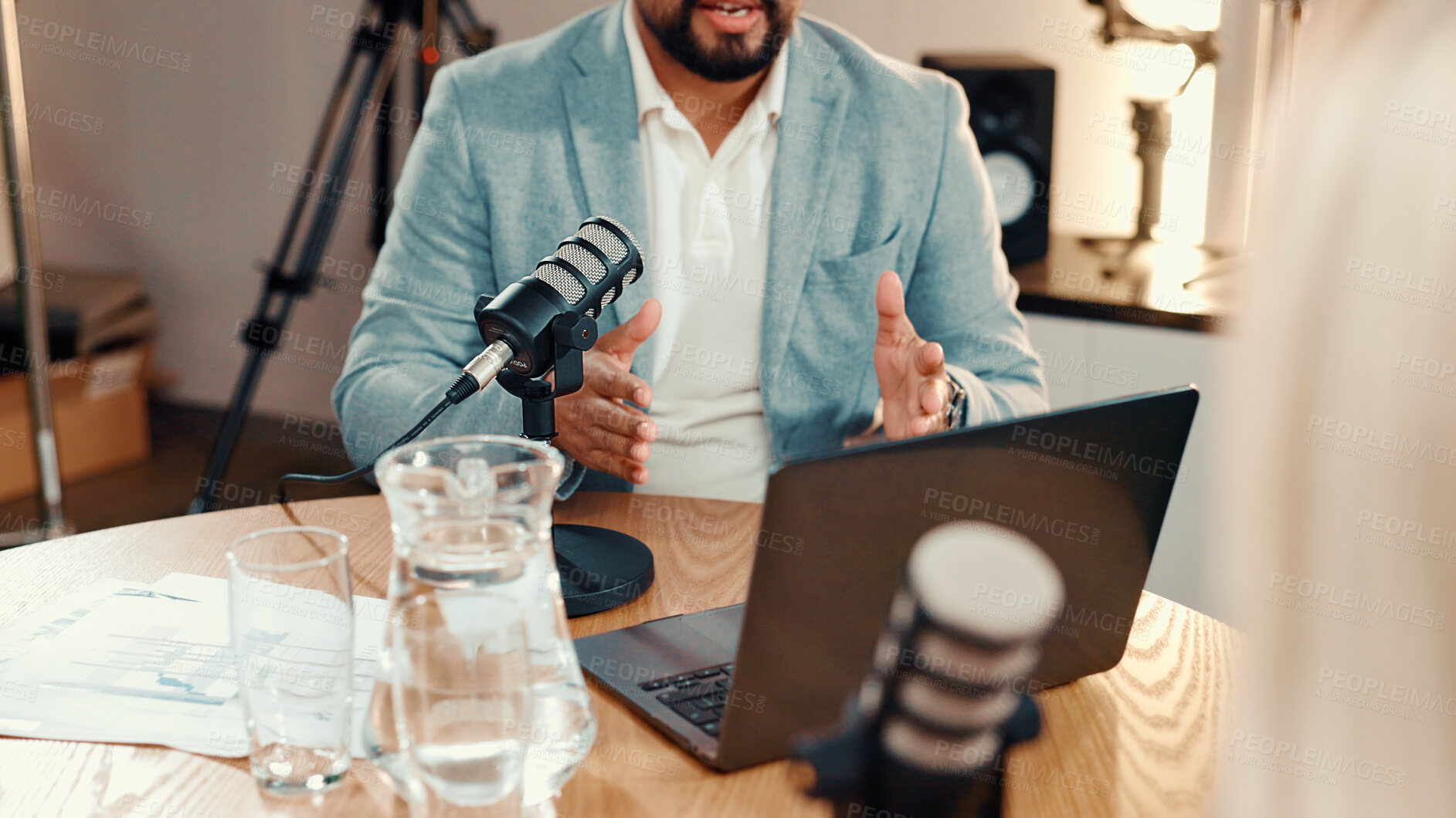 Buy stock photo Hands, man and mic for interview in studio with guest, audio broadcast and live streaming chat. Presenter, laptop and question celebrity in talk show, target audience and discussion for media podcast