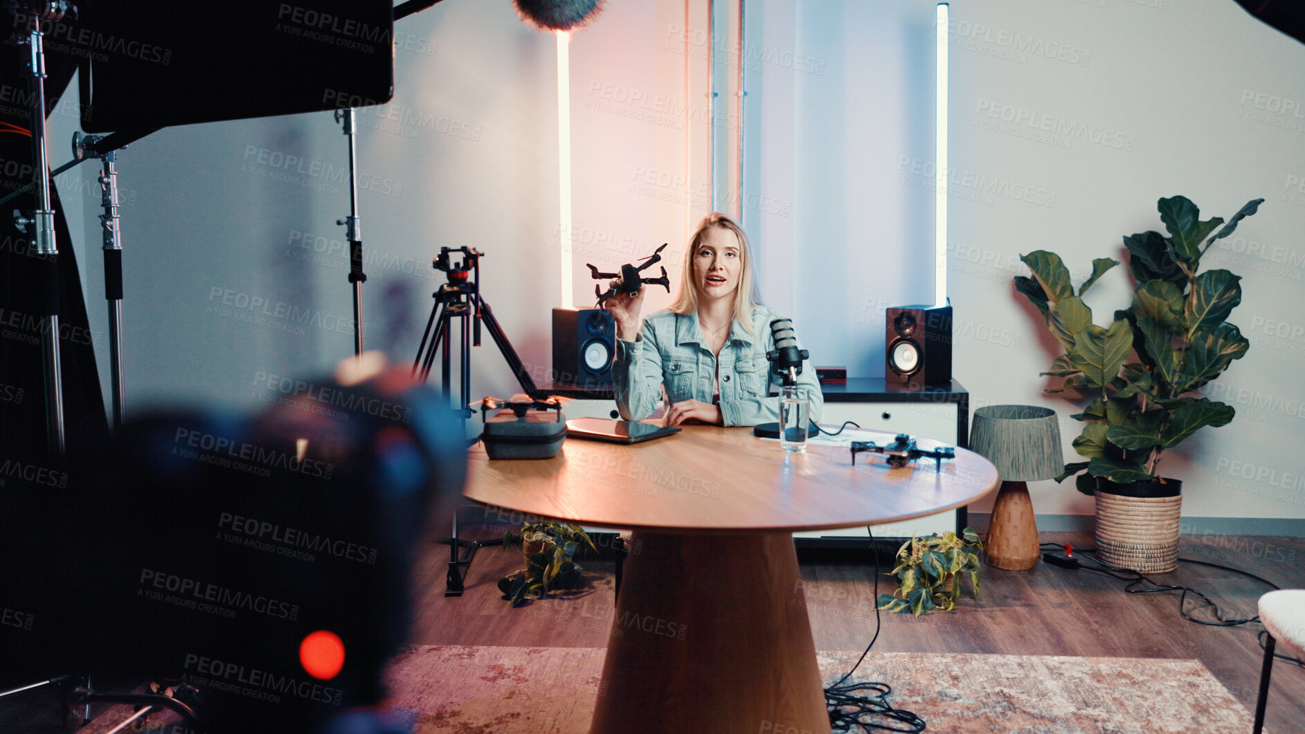 Buy stock photo Influencer, live streaming and woman with drone for review, feedback and advice with tech in studio. Content creator, speaker and person with camera for product test, tutorial or talking to audience