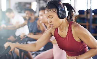 Buy stock photo Headphones, gym and woman on stationary bike for fitness, training and cardio workout for health. Sports club, sweat and people on machine for cycling, wellness or exercise with music, radio or audio