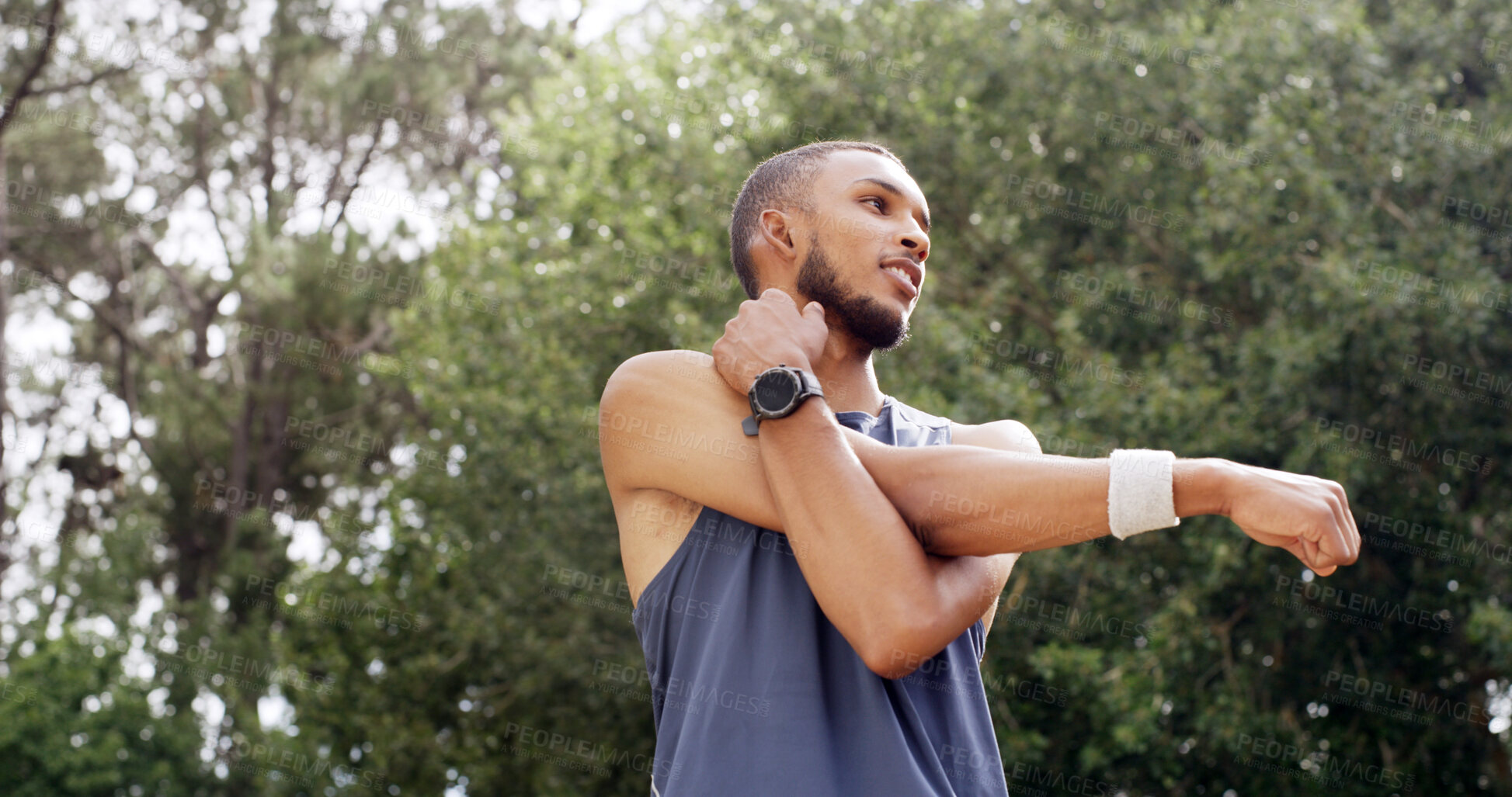 Buy stock photo Fitness, stretching and man outdoor at park for exercise, low angle and training with smile. Male athlete, start arm muscle warm up and happy in nature for workout, wellness and thinking of health