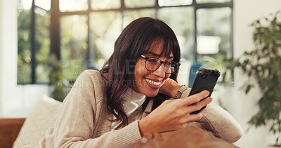 Buy stock photo Woman, phone and relax on sofa with smile, contact and texting for online dating in living room. Person, happy and smartphone with mobile app, web chat and check notification on couch at apartment