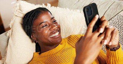 Buy stock photo Black woman, mobile and relax on couch with social media, text message and reading online blog. Person, phone and smile in home living room for funny email, meme website and chill with chat platform
