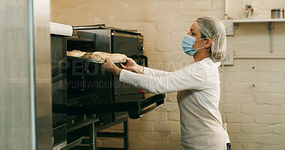 Buy stock photo Bakery, woman and donuts in oven in kitchen for breakfast order, baking process and catering service. Hospitality industry, baker and mask in small business for dessert preparation and pastry snack