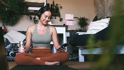 Buy stock photo Music, phone and yoga with woman in living room of home for holistic or wellness routine. App, communication and headphones with Asian person on apartment floor for social media post or update