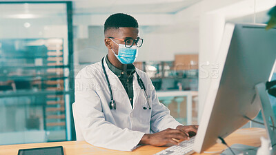 Buy stock photo Black man, doctor and typing on computer in clinic for medical history, report or PPE for safety. Desktop, mask and healthcare worker reading email for wellness, schedule and research in office