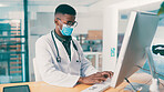 Black man, doctor and typing on computer for medical history, report or insurance records. Desktop, mask and healthcare worker reading email for wellness, clinic schedule or research in office