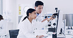 Lab, scientists and people with computer, teamwork or medical research with tech to identify cancer. Woman, discussion and man with microscope for disease diagnosis, point and collaboration for cure