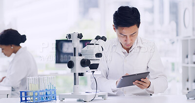 Buy stock photo Man, scientist and reading on tablet in lab for research, medical study and experiment results. Person, coworking or microscope with digital, online checklist and healthcare feedback on vaccine trial