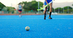 Hockey stick, ball and legs on field for training practice, physical activity and sports game outdoor. Fitness, coordination and people running on astro turf to pass, players and match preparation.