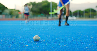Buy stock photo Hockey stick, ball and legs on field for training practice, physical activity and sports game outdoor. Fitness, coordination and people running on astro turf to pass, players and match preparation.