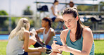 Texting, athlete and woman with smartphone, sports field and communication with contact for updates. Outdoor, online and person with with mobile for chat, typing and message with tech on break