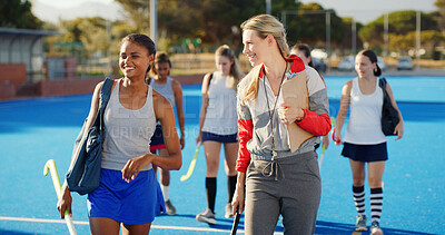 Buy stock photo Walking, hockey and women outdoor with coach talking after training, practice and exercise. Team, happy and people in conversation after playing match, game and tournament on turf for sports hobby