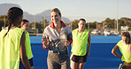 Field hockey, talking and coach with women outdoor for training, practice and match strategy. Sports hobby, fitness and people on turf with exercise for playing match, competition and tournament