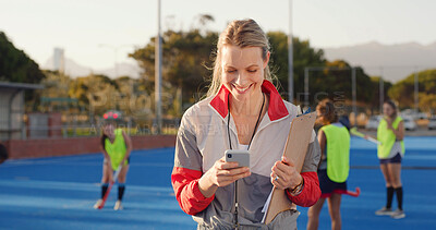 Buy stock photo Coach, hockey field or happy woman with phone for match organization, event info or opponent approval. Planning, mobile or sport trainer with clipboard on turf, game arrangement and local league team