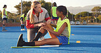 Women, coach, and player with knee pain, accident and instructor with training. People, hockey athlete or medical assistance with strain, joint injury or torn muscle with tension, outdoor or talking
