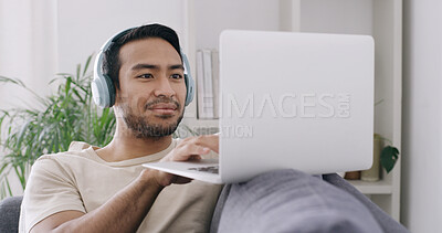 Buy stock photo Man, laptop and relax with headphones on sofa, typing and search for movies, streaming or video at home. Person, computer and audio for smile, subscription and film on couch in lounge at apartment