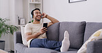 Relax, phone and headphones with man on sofa for streaming, radio station and audio playlist. Podcast subscription, music and media platform with person in living room of home for connection