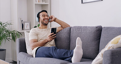 Buy stock photo Relax, phone and headphones with man on sofa for streaming, radio station and audio playlist. Podcast subscription, music and media platform with person in living room of home for connection