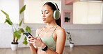 Mobile, headphones and woman in studio for fitness music, radio or streaming sound on break. Phone, audio and person in health club for online podcast, exercise and listening to playlist on internet